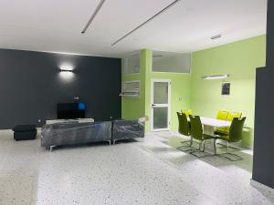 a room with green and black walls and a table and chairs at Les Résidences de Gorée in Cotonou