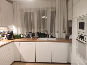 a white kitchen with a sink and a window at Pod Skrzydłami Podlasia in Siemiatycze