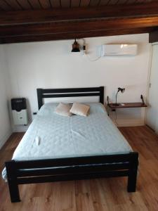 un letto con due cuscini sopra in una stanza di HERMOSA CASA QUINTA TOTALMENTE EQUIPADA ( arroyo del medio) a Villa Constitución