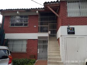a red brick building with a gate and a garage at Apartamento Malí en Cali in Cali