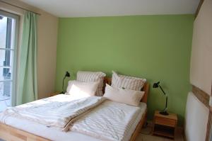 una camera da letto con un letto con lenzuola bianche e una finestra di Ferienwohnung Rheinsberg Altstadt a Rheinsberg