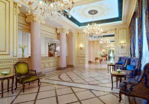 a large room with a chandelier and a lobby with chairs at Hotel Bristol in Odesa