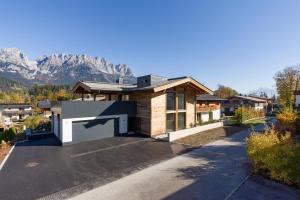 a house with a driveway with mountains in the background at Zum Wilden Mats in Going