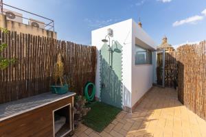 einen kleinen Hinterhof mit einem Zaun und einer Terrasse in der Unterkunft Tentudia Charming Apartments with Private Roof-Top or Patio in San Bernardo By Oui Seville in Sevilla