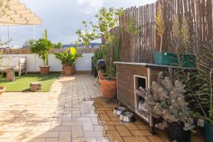 a patio with a fireplace in a backyard with potted plants at Tentudia Charming Apartments with Private Roof-Top or Patio in San Bernardo By Oui Seville in Seville