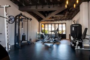 a gym with several treadmills and machines in a room at Portomar Apartments - 4-Star Superior Hotel in Portocolom