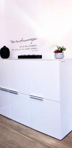 a white dresser with a sign on top of it at Puro-Design-Apartment Deluxe - very central in Munich