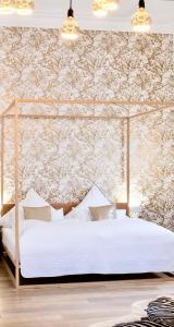 a bedroom with a white bed with a floral wallpaper at Puro-Design-Apartment Deluxe - very central in Munich