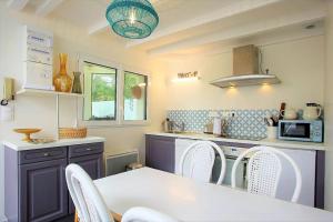 a kitchen with a white table and chairs in it at Les beaux châteaux in Vouvray