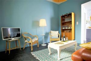 - un salon avec une table, des chaises et une télévision dans l'établissement Les beaux châteaux, à Vouvray