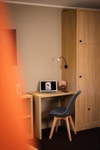 a desk with a laptop and a chair in a room at Best Inn in Bydgoszcz