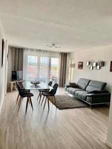 a living room with a couch and a table and chairs at Roanne-centre appartement in Roanne