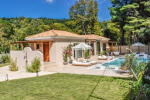 a backyard with a pool and a house at Mandraki Village Boutique Hotel in Koukounaries