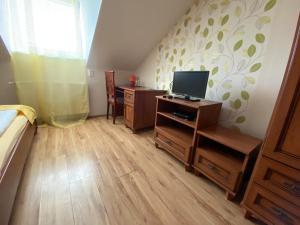 1 dormitorio con 1 cama y escritorio con TV en Penzión Alejová, en Košice