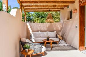 a patio with a couch and a table at Mandraki Village Boutique Hotel in Koukounaries
