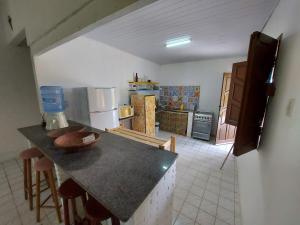 a kitchen with a counter top and a kitchen with a refrigerator at Sítio no Litoral Norte para curtir! in Subaúma