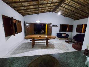 a living room with a wooden table and a couch at Sítio no Litoral Norte para curtir! in Subaúma