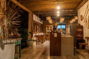 a restaurant with wooden ceilings and tables and potted plants at Taipu Bay Pousada - Taipu de Fora in Barra Grande