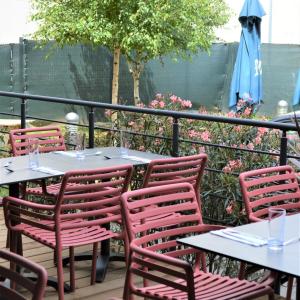 een groep tafels en stoelen op een patio bij ibis Lyon Sud Oullins in Oullins