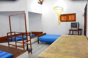 Una cama o camas en una habitación de Family Rest Rooms Anuradhapura
