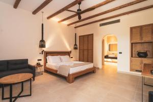 um quarto com uma cama e uma cadeira em Kouros Blanc Resort & Suites em Pounda