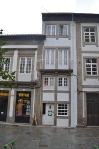 un gran edificio de ladrillo con ventanas blancas y balcones en Casa Augusta AL en Braga