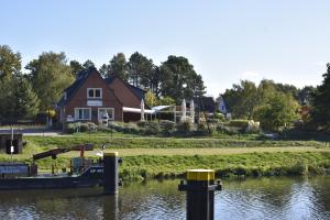 Pension zur Schleuse am Elbe Lübeck - Kanal in Witzeeze في Witzeeze: قارب في الماء امام المنزل
