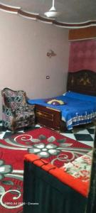 a bedroom with two beds and a table and a chair at الضيافة in Shakshuk