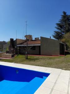 a swimming pool in front of a house at ESTANCIA VIEJA (CARLOS PAZ) in Estancia Vieja