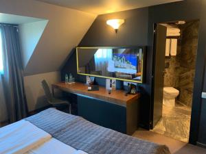 a bedroom with a bed and a desk with a television at All Seasons Residence Design Hotel - Free parking in Sofia