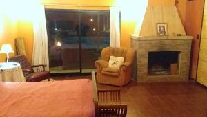 a living room with a fireplace and a chair at Casa quinta en Mercedes, Bs As in Mercedes +14 photos