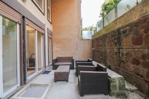 un gruppo di panche sedute accanto a un muro di mattoni di Delicious 2 Bed Room Apartment and Garden by YH a Roma