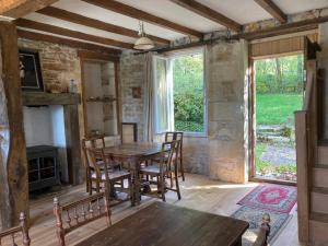 ein Esszimmer mit einem Holztisch und Stühlen in der Unterkunft Rustic cottage with stunning swimming pool in Saint-Front + 26 Fotos