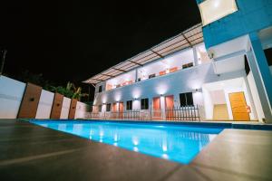 a swimming pool in front of a house at night at The Concept Hotel Langkawi in Kuah