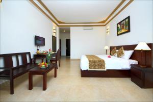 a hotel room with a bed and a couch and a table at Green Areca villa in Hoi An
