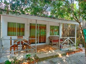 a house with stained glass windows and a table at Sweet Time Bungalows in Koh Rong Sanloem