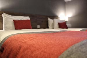 a hotel room with two beds with red and white pillows at Devoncove Hotel Glasgow in Glasgow