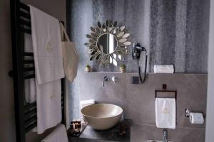 baño con lavabo y espejo en Divina Charme en Mascalucia
