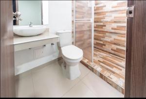 a bathroom with a toilet and a sink and a shower at Hotel Millrose in Valledupar