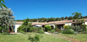 una casa con un jardín delante de ella en gîtes "Entre les Vignes", en Tourreilles