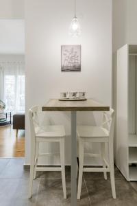 a white dining room table with two white chairs at NAVA Apartment in the center of Thessaloniki in Thessaloniki