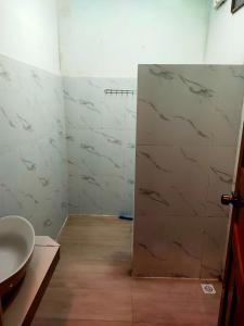 a bathroom with a sink and a door with marble walls at Sweet Time Bungalows in Koh Rong Sanloem