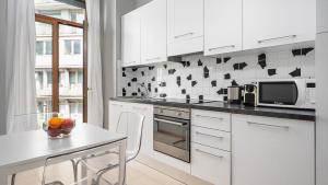 a white kitchen with a table and a microwave at Italianway - Cannobio 8 in Milan