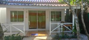 a white house with glass doors and a tree at Sweet Time Bungalows in Koh Rong Sanloem