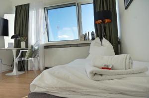1 dormitorio con 1 cama con sábanas blancas y ventana en coSI Apartment im SI-Centrum Stuttgart en Stuttgart