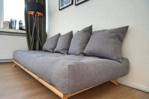 a couch with six pillows on it in a room at coSI Apartment im SI-Centrum Stuttgart in Stuttgart