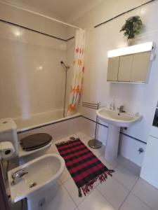 uma casa de banho com um lavatório, um WC e um lavatório. em Logement terrain de tennis/piscine 800m de la mer em Portimão