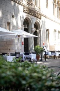 里昂的住宿－Hôtel de l'Abbaye Lyon - Boutique Hôtel，大楼前的餐厅,配有桌子和遮阳伞