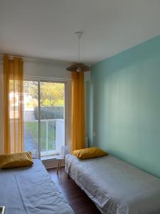 2 Betten in einem Zimmer mit Fenster in der Unterkunft Appartement face mer LA BAULE in La Baule