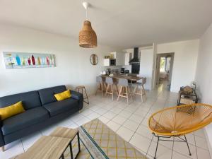 ein Wohnzimmer mit einem blauen Sofa und einem Tisch in der Unterkunft Appartement face mer LA BAULE in La Baule